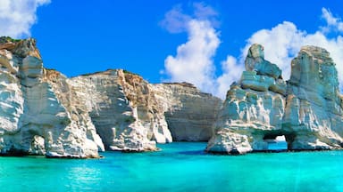 A coastal landscape with white limestone cliffs and a clear turquoise sea.