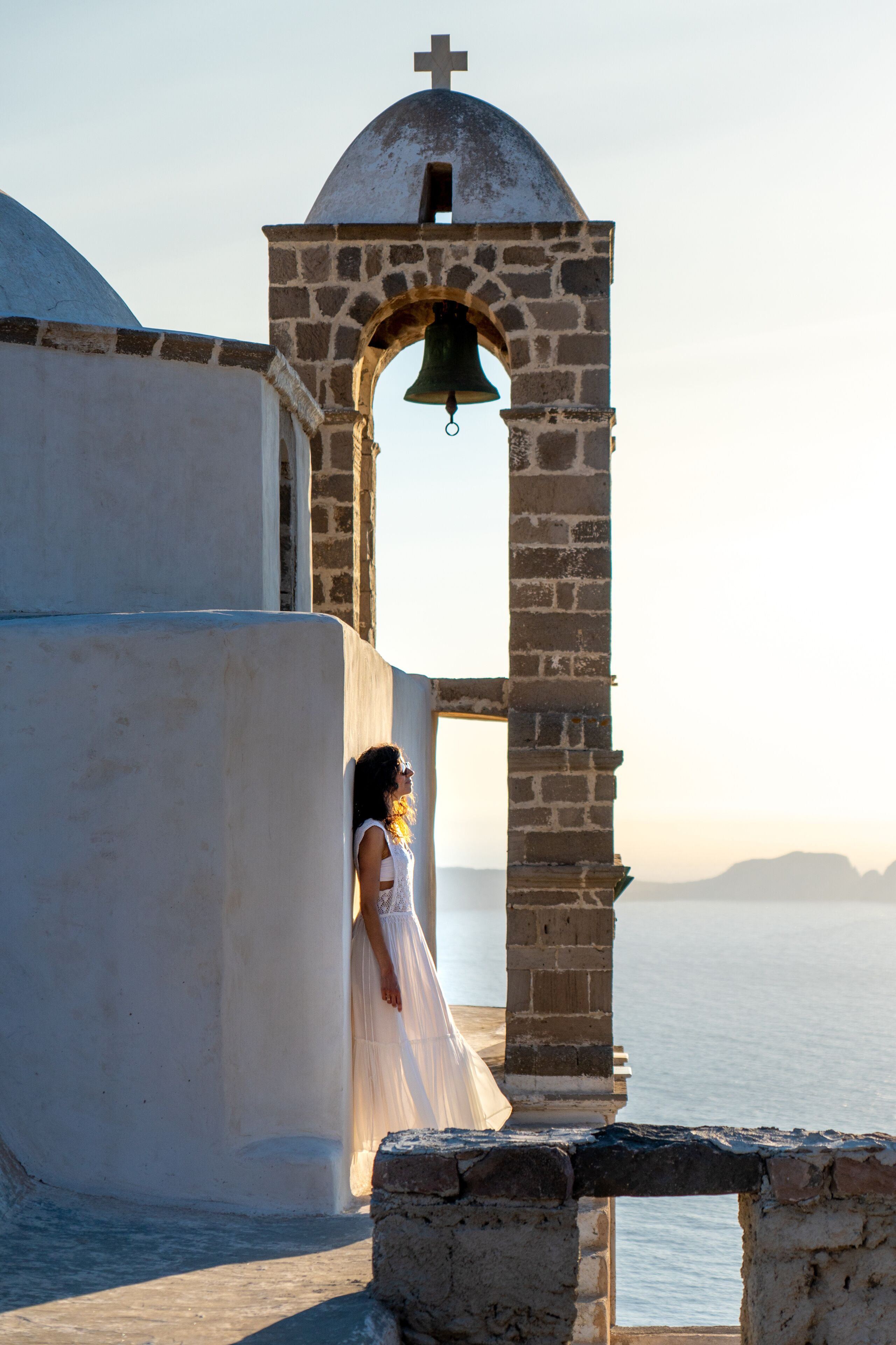 Woman in white dress looking at the sea in Plaka, MIlos