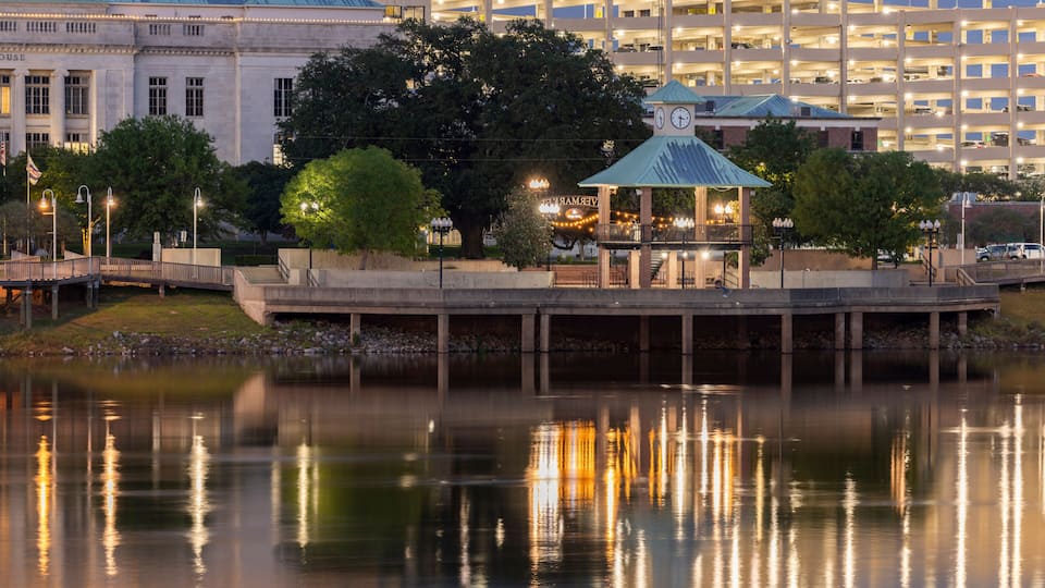 Monroe, Louisiana, USA - April 4, 2024: Evening lights shine on the historic buildings, skyline and river of downtown Monroe.