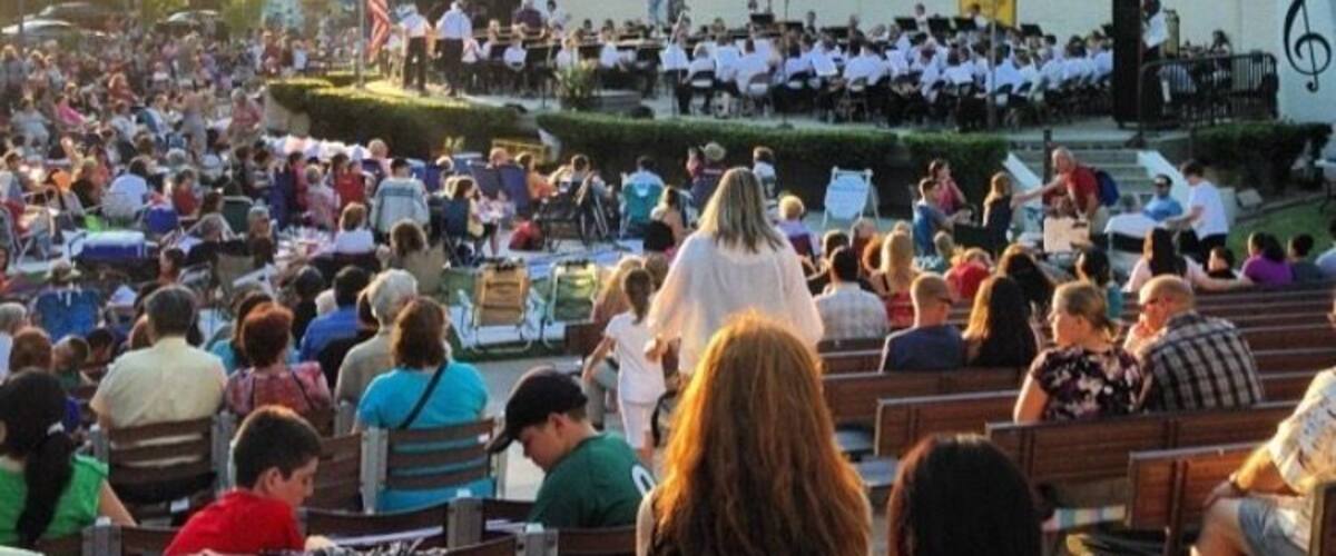 A large outdoor amphitheater with a dome roof, surrounded by a crowd of people.
