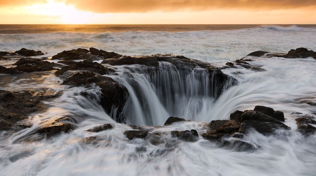 Thor's Well on the Oregon coast appears to be the end of the earth. Also known as the drainpipe of the Pacific, the well is actually a hole in the rock that only appears to drain water from the ocean. In reality the huge hole is likely only around 10 meters deep. Even if the well is not quite as magic as it seems, it still manages to produce amazing sights, though not for the faint of heart!.
The site is most spectacular at high tide when the water washes violently over the rocks and funnels into the hole. I arrived here just before sunset and as I made my way down to the spot I saw small group of photographers standing on a rock right in front of the hole with their tripods already setup and taking photos. I managed to squeeze myself between a couple of photographers and began shooting however it wasn't long before the waves got higher and eventually swept up onto the rock we were all standing on, soaking our feet. We would have easily been swept away by the torrent had it not been for the rock we were all standing on. The sky was stormy and as the sun set over the horizon the colour in the sky turned a beautiful orange glow , perfect.