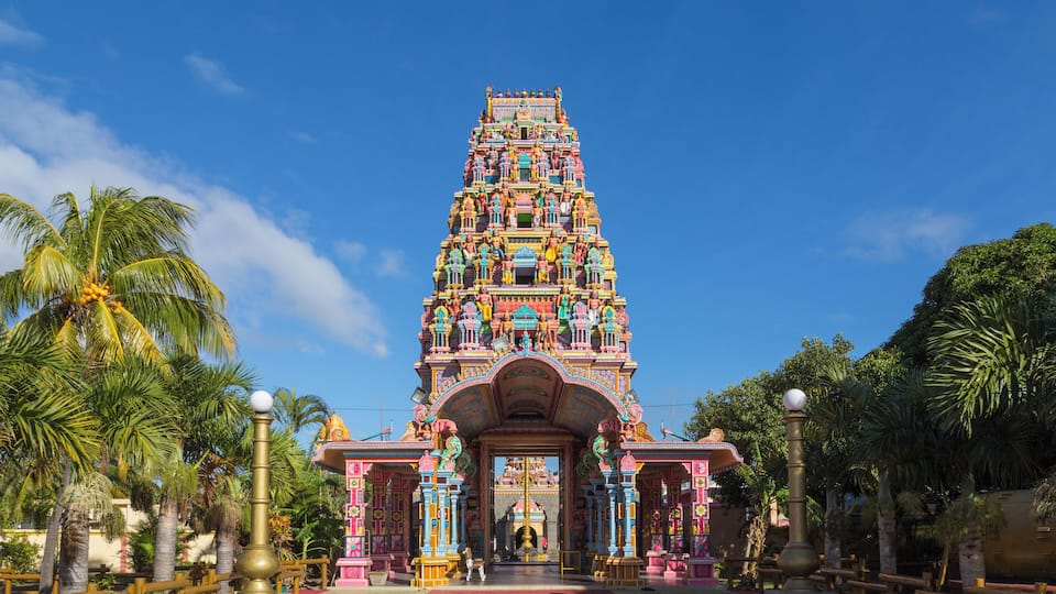 A colorful temple with intricate architecture and a red pathway leading to it.