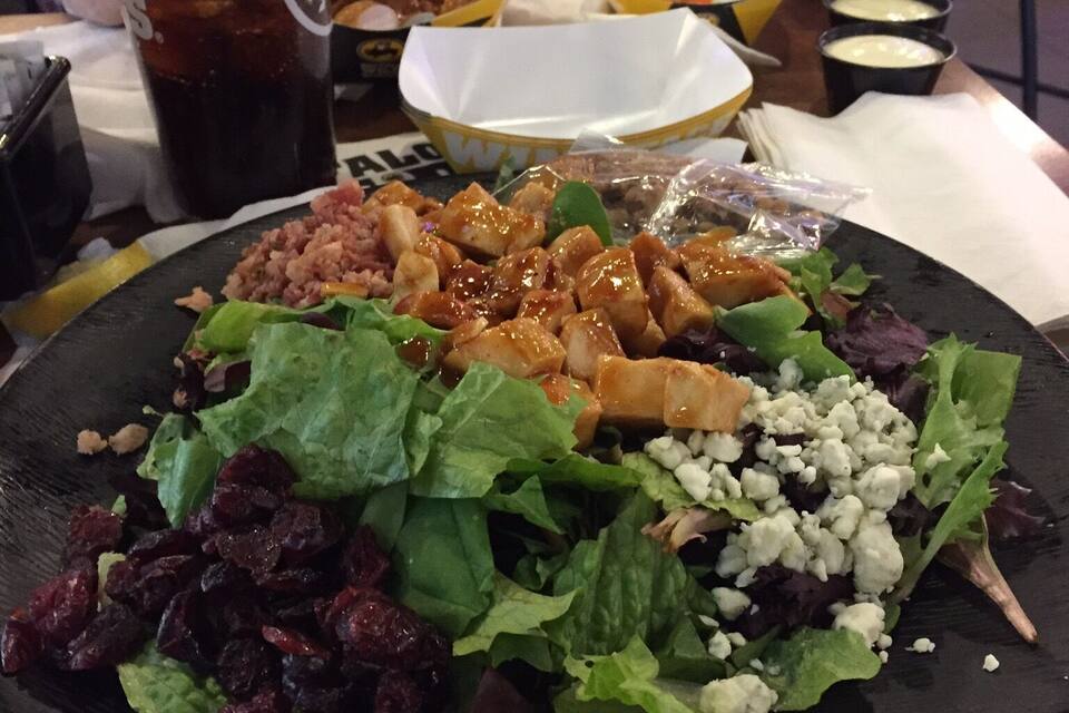 A plate of food with various items including a salad, meat, and a drink.