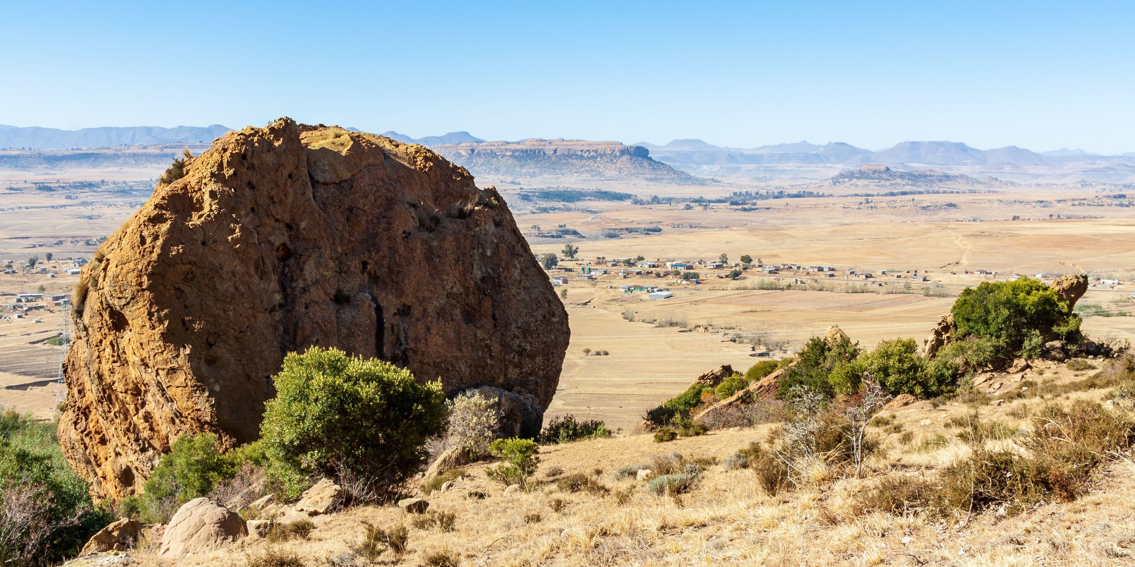 This big rock used to be a part of a plateau near Maseru, Lesotho. Now it stands proud overlooking a nearby village with a mountain in the background.