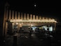 Vue nocturne du Café Du Monde, un café historique reconnaissable à son auvent rayé et à son enseigne illuminée.