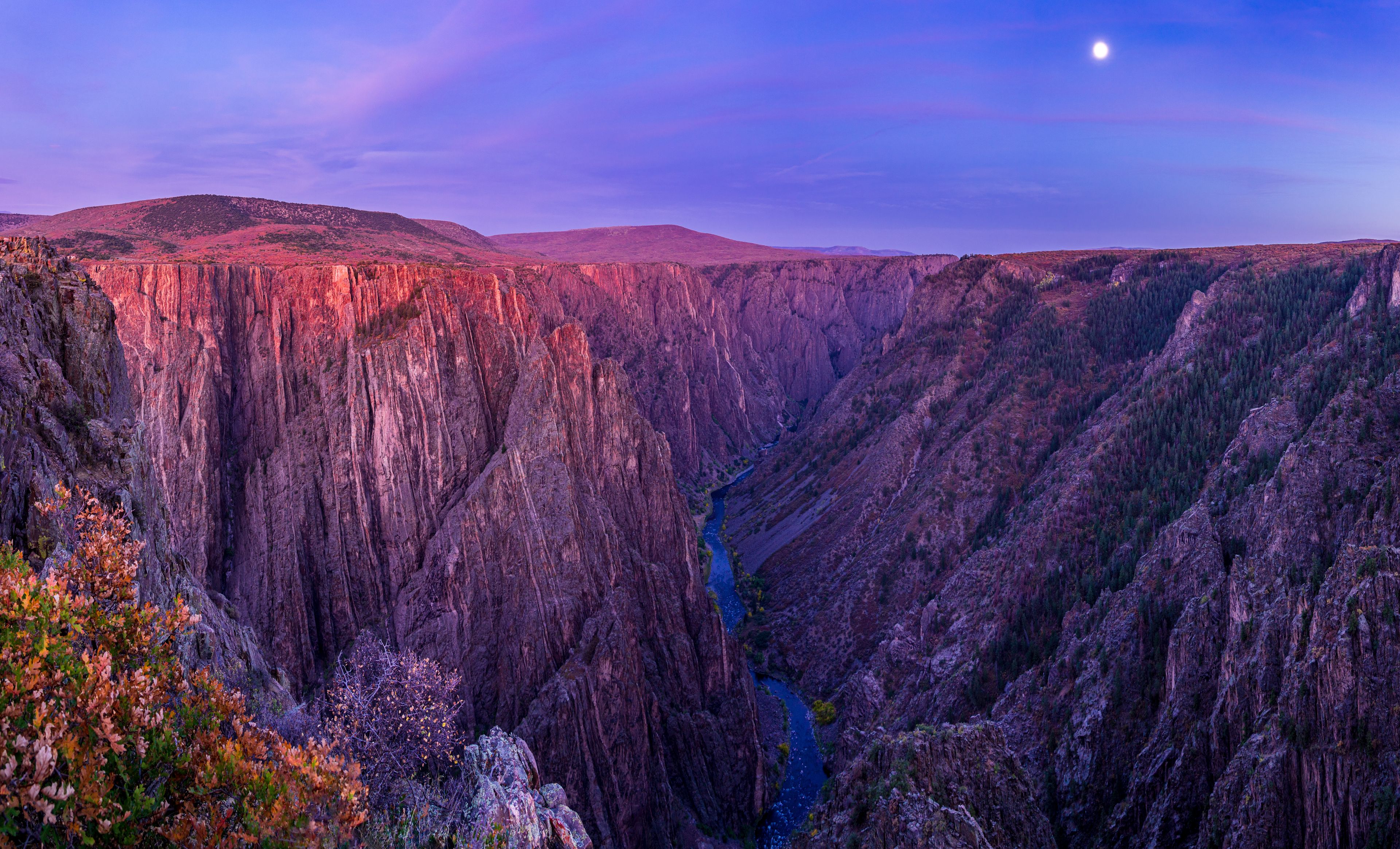 A canyon with steep cliffs and a river running through it.