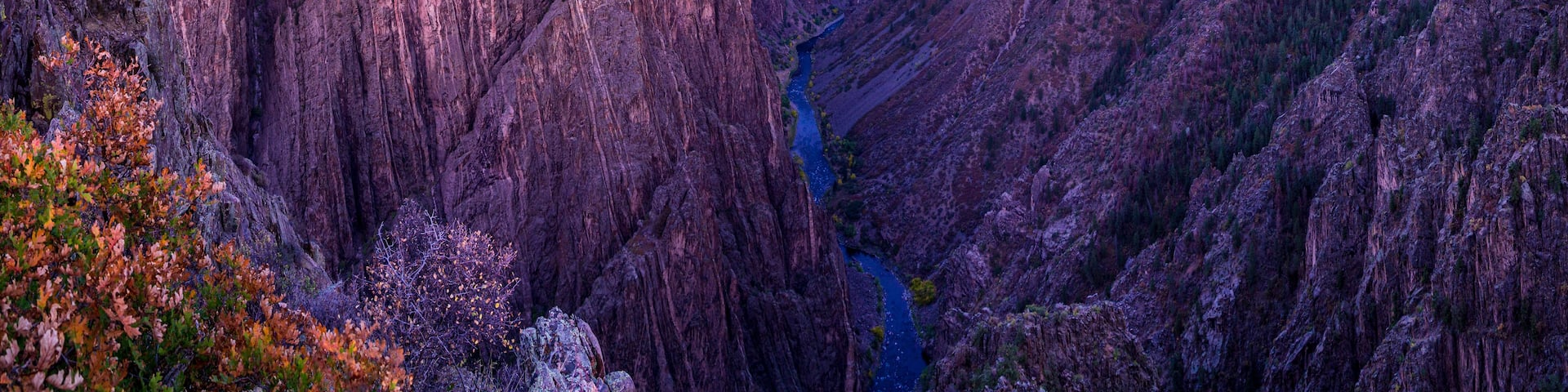A canyon with steep cliffs and a river running through it.