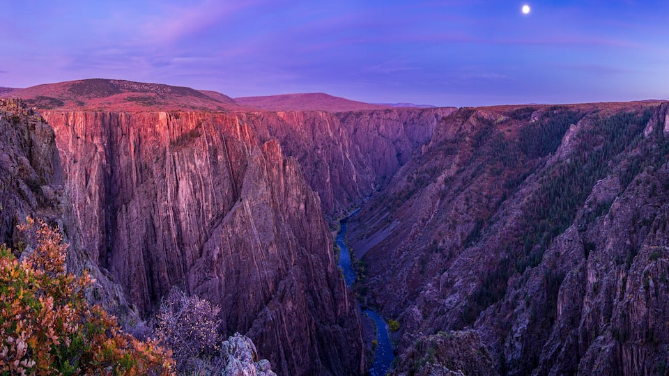A canyon with steep cliffs and a river running through it.