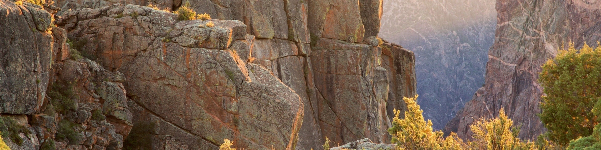 A rugged mountain landscape with rocky cliffs and dense greenery.