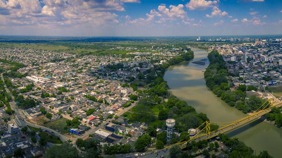 A river flowing through a densely populated city with a bridge crossing it.