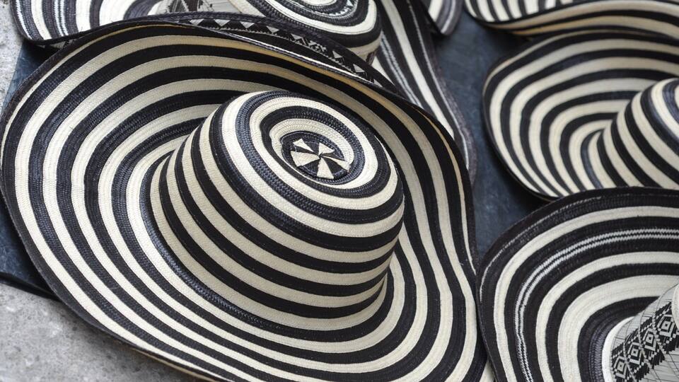 A collection of black and white striped hats with a central design.