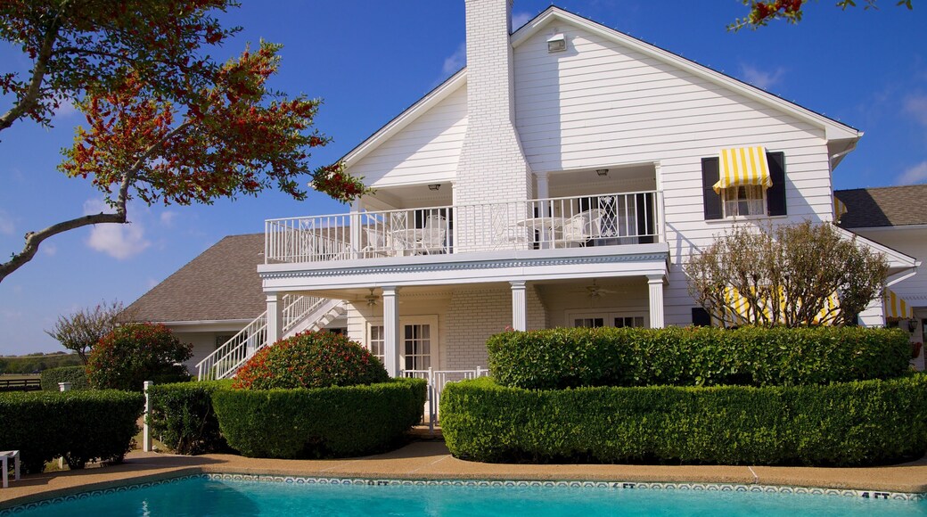 Southfork Ranch showing a pool and a house