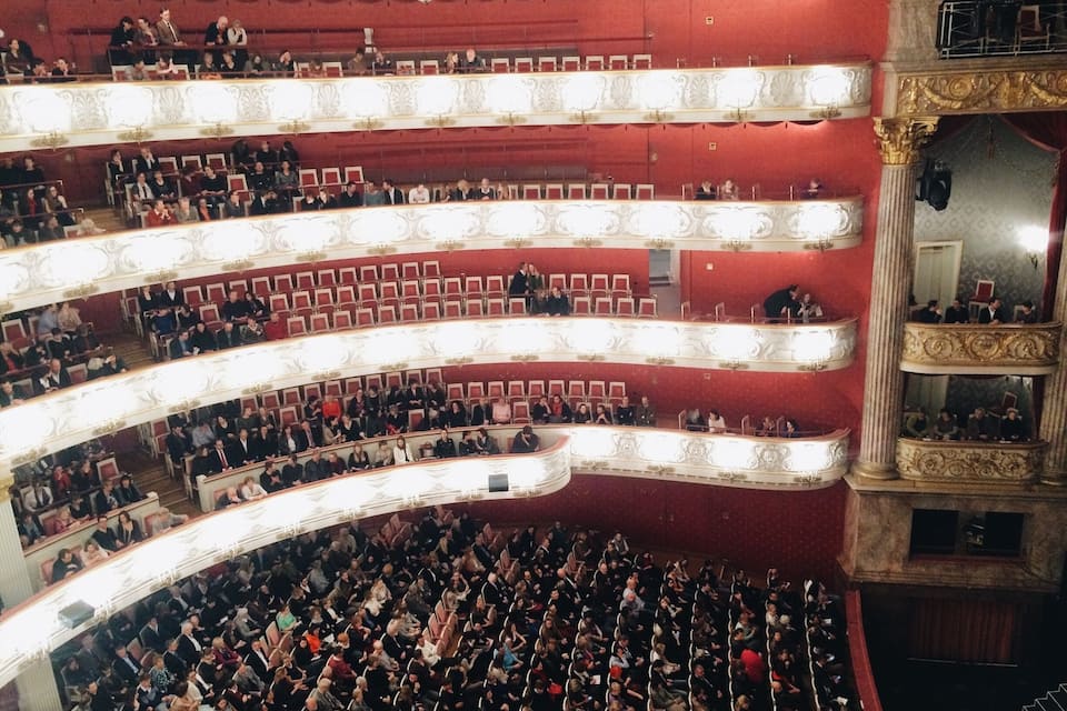 Um teatro imponente com várias galerias e fileiras de assentos.