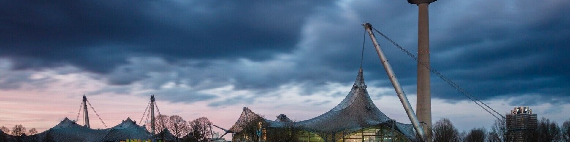 Een moderne toren met een uniek ontwerp, een grote tentachtige constructie en een rustig waterlichaam.