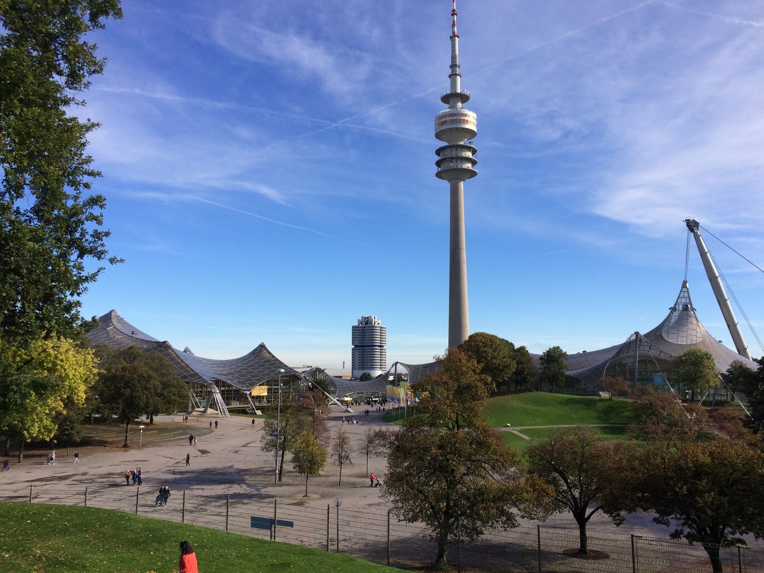Una torre, una noria y un parque con gente.