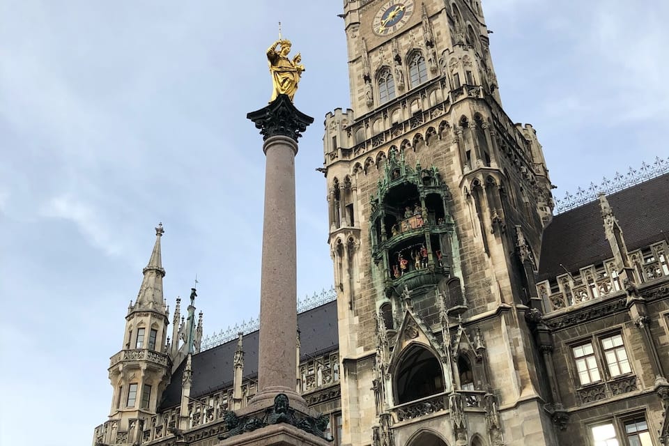 Un bâtiment historique à l’architecture riche et élaborée, comprenant une haute tour dotée d’une horloge et de statues.