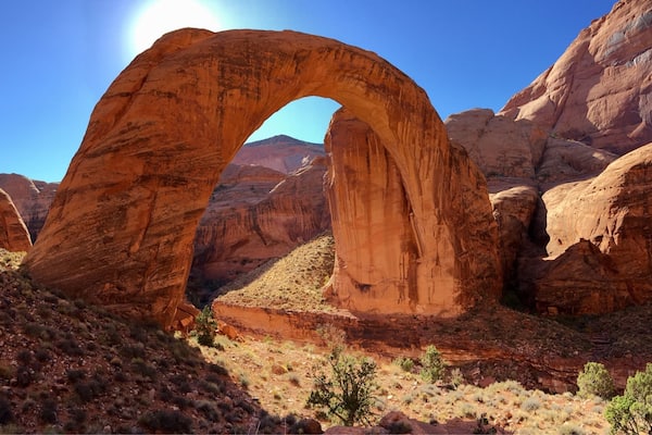 A large natural arch formation in a desert landscape.