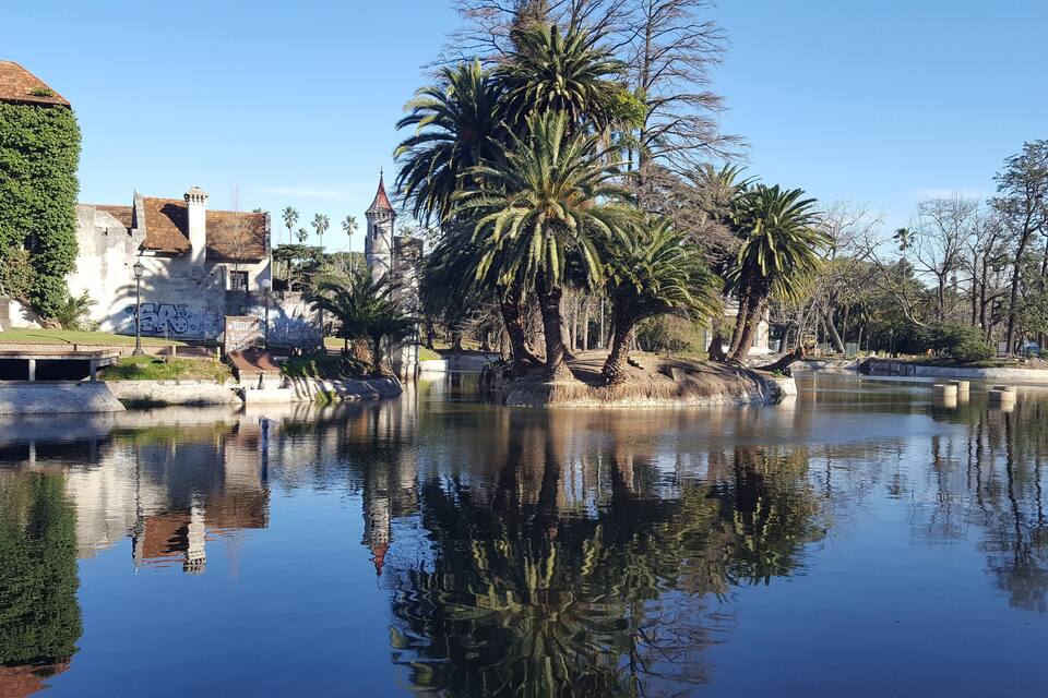 Un riu tranquil que reflecteix edificis i palmeres.