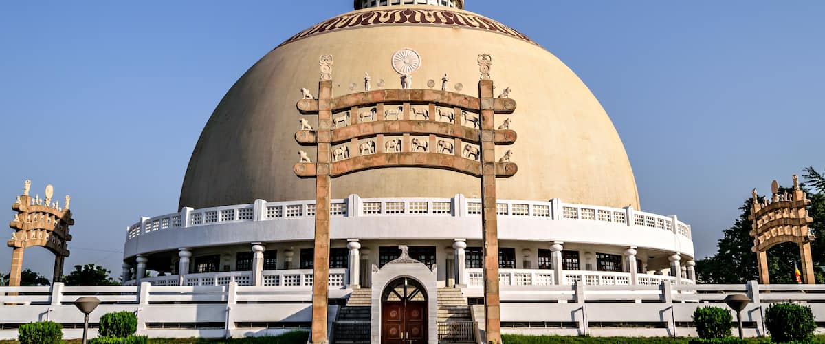 A large, domed building with a circular entrance and statues.