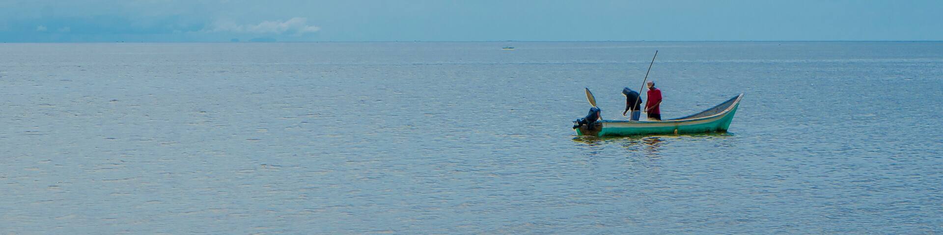 Necoclí, Antioquia, Colombia. May 12, 2024. People fishing a boat at sea