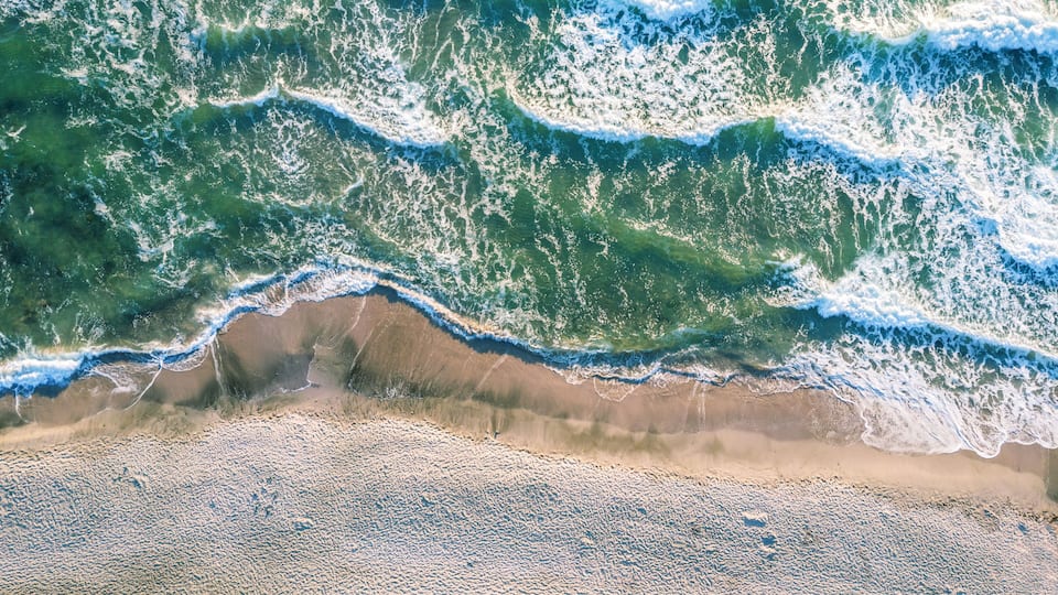A beach with waves crashing onto the shore.