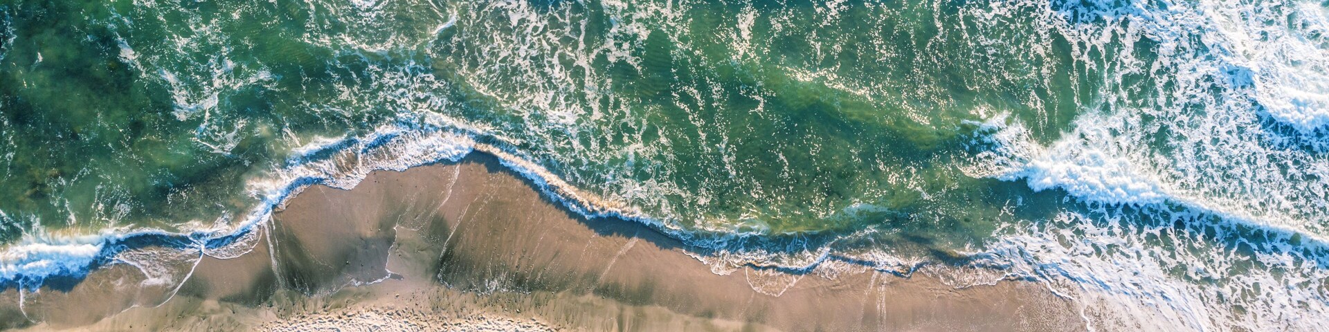 Una playa con olas rompiendo en la orilla.
