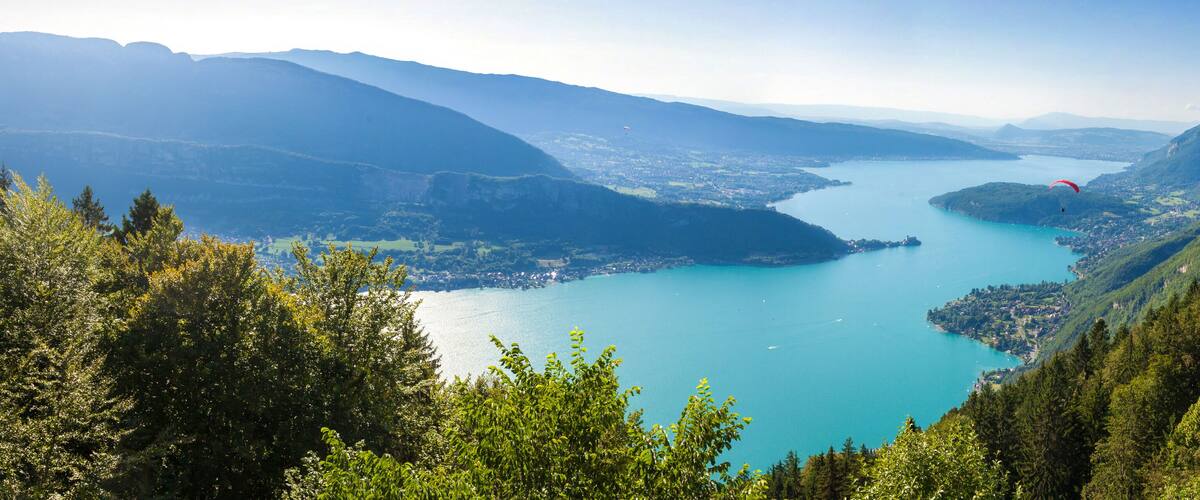 A lake surrounded by mountains and forested hills.