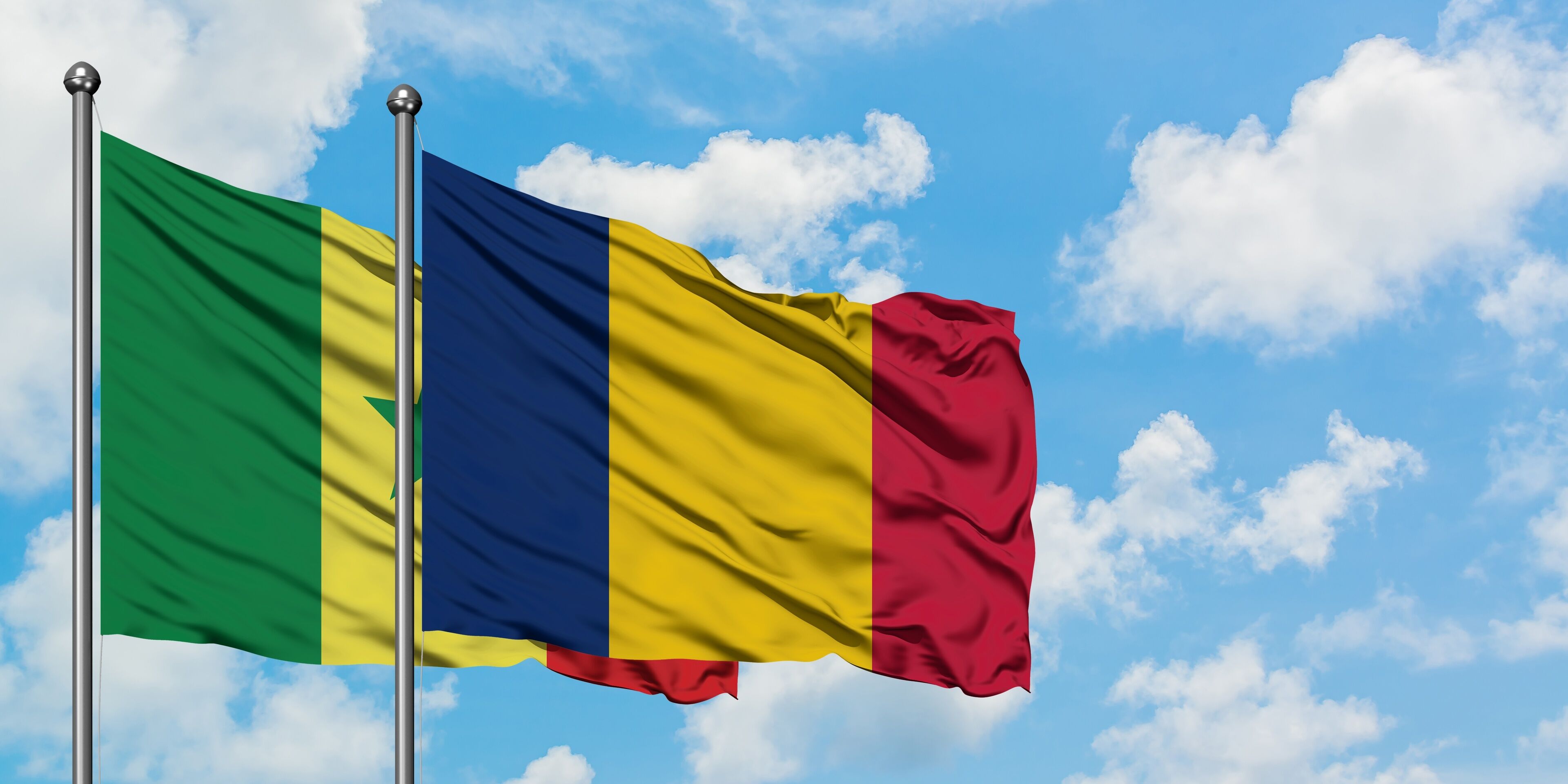 Senegal and Chad flag waving in the wind against white cloudy blue sky together. Diplomacy concept, international relations.