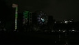 A nighttime cityscape with illuminated buildings and a large spherical structure.