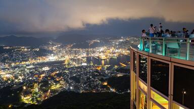 Une vue nocturne d’une ville, avec des bâtiments illuminés et une rivière.