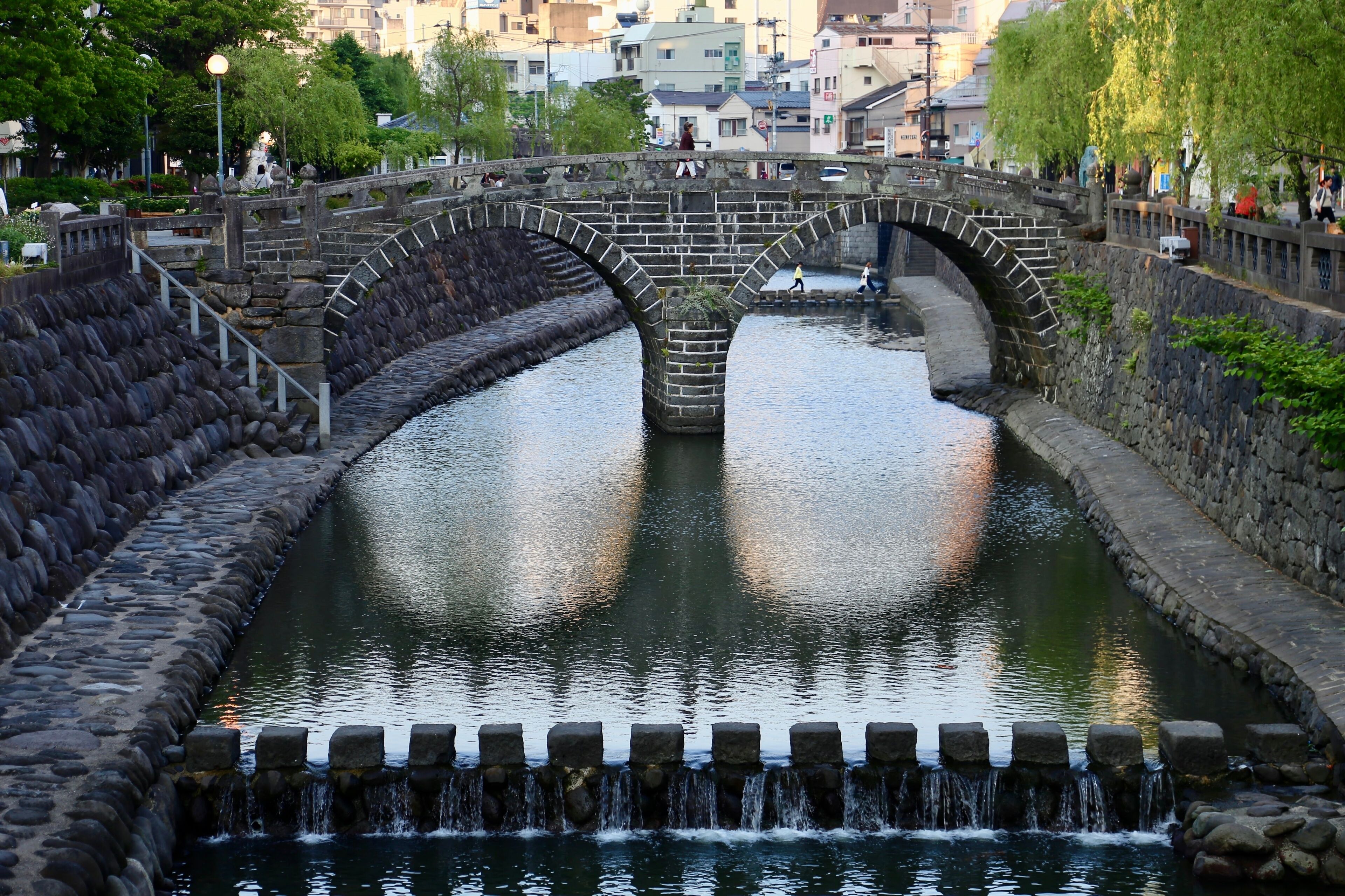 Un puente de piedra sobre un canal con agua corriendo.