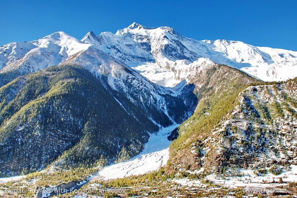 A snow-covered mountain range with a glacier.