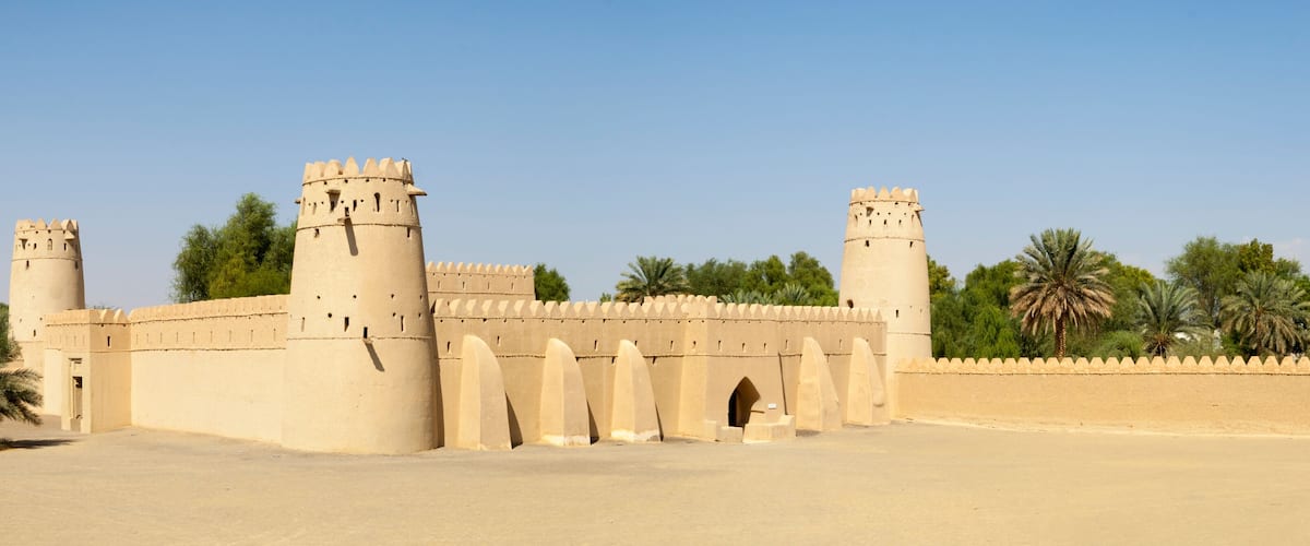 A large, beige fortress with multiple towers and a surrounding wall.