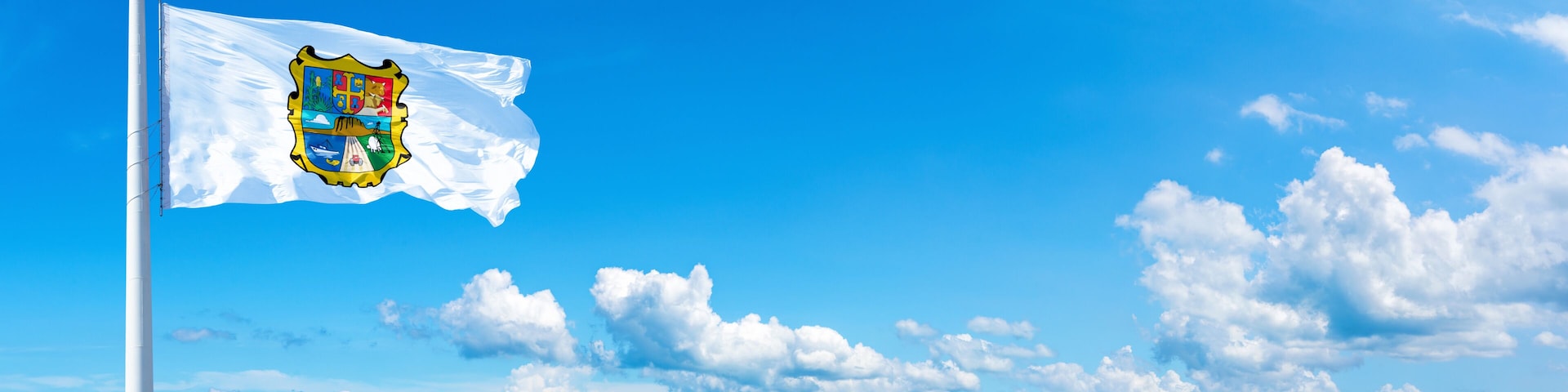 Tamaulipas, state of Mexico - flag waving on a blue sky in beautiful clouds - Horizontal banner