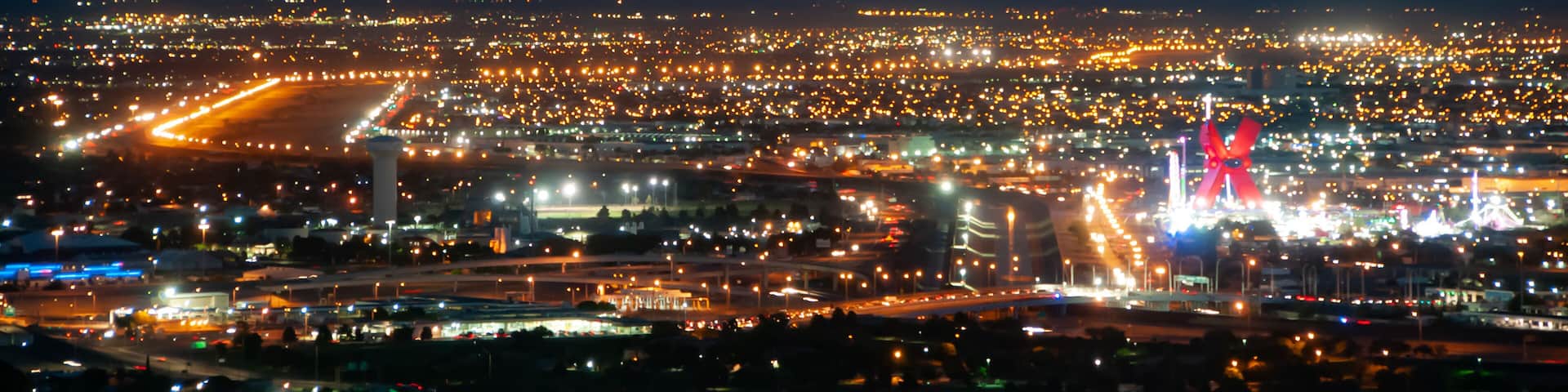 Night view of the international border between the US and Mexico in El Paso, Texas, seen from Scenic Drive. Visible are the Rio Grande, an entry bridge, and the wall between the countries.