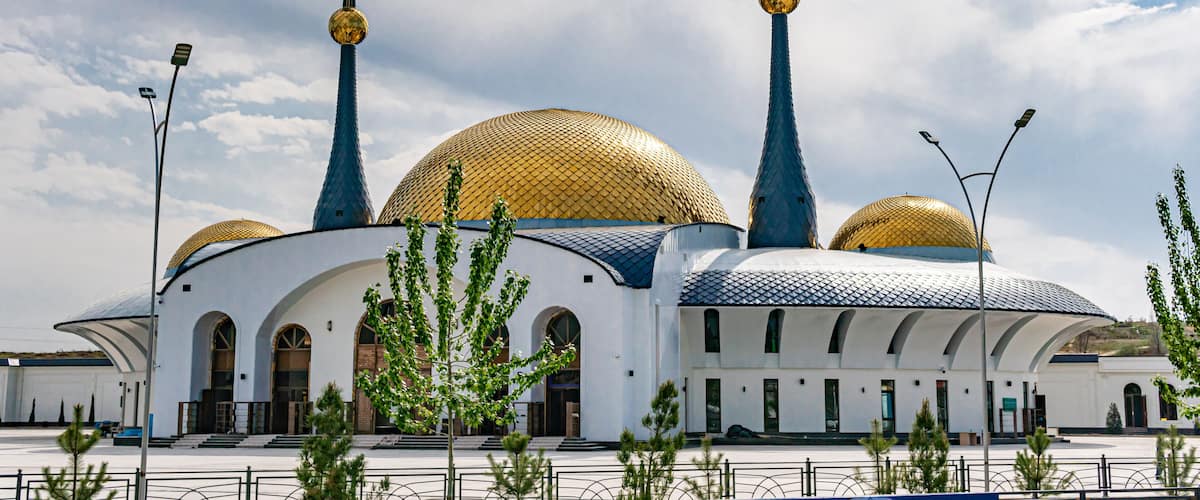 A mosque with golden domes and blue spires.
