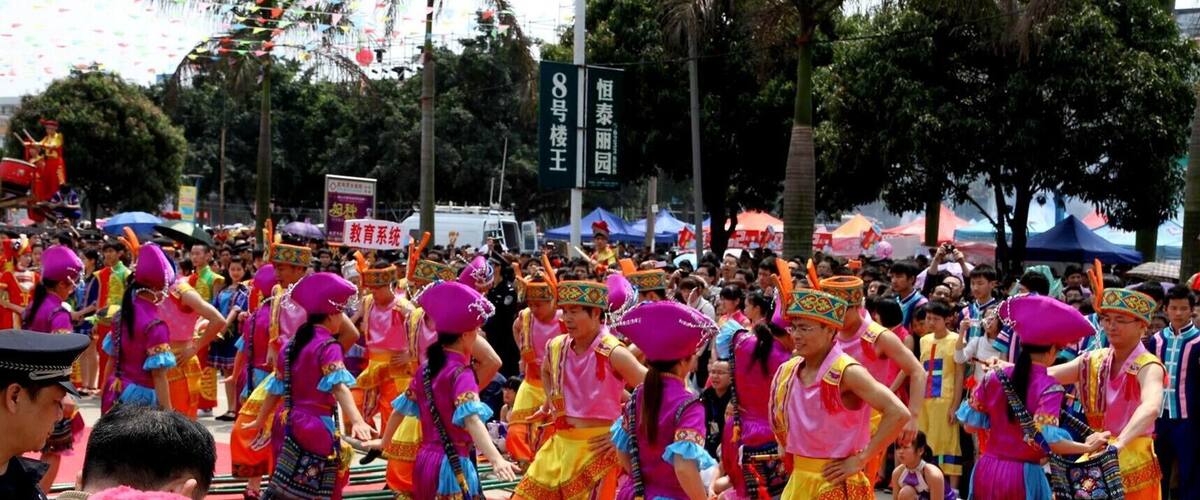 Un grupo de personas vestidas con trajes tradicionales coloridos realizan una danza sobre una alfombra roja.