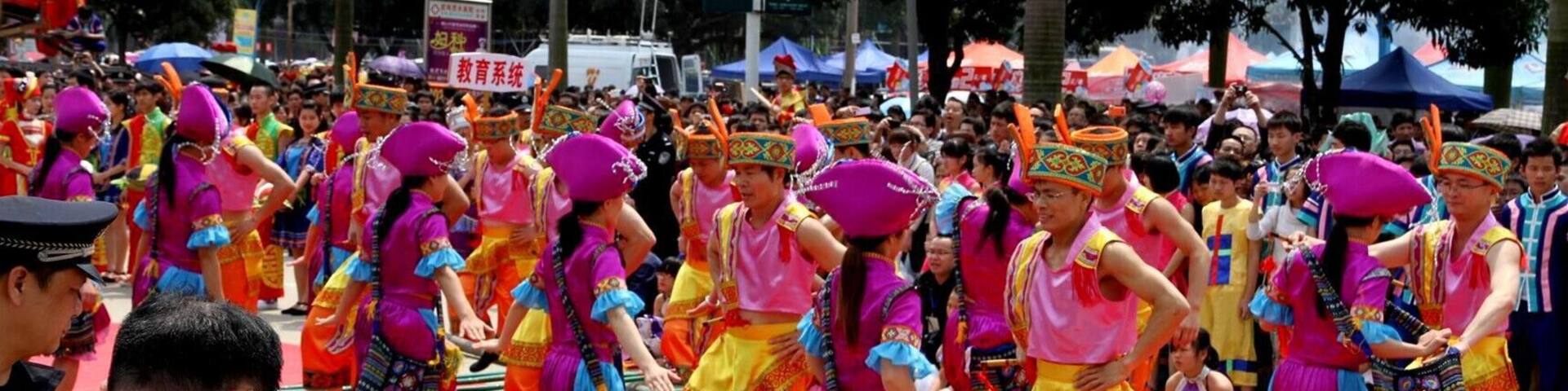 A group of people in colorful traditional costumes performing a dance on a red carpet.