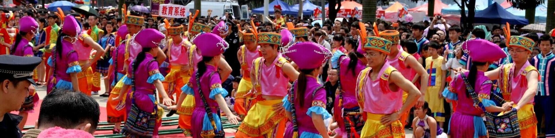 Un grupo de personas vestidas con trajes tradicionales coloridos realizan una danza sobre una alfombra roja.