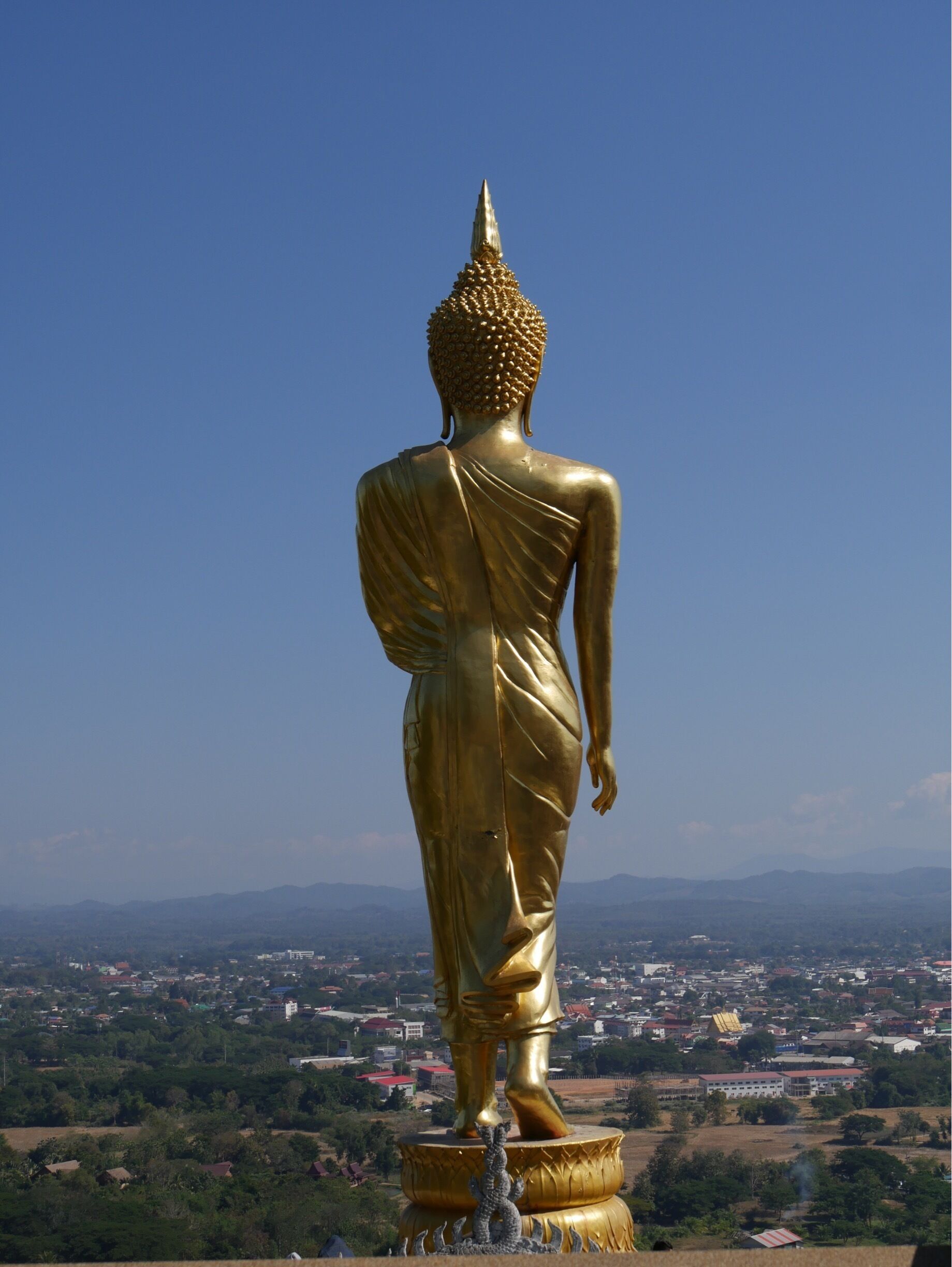 Walking Buddha Statue at Wat Phra That Khao Noi overlooking the city of Nan, Thailand.