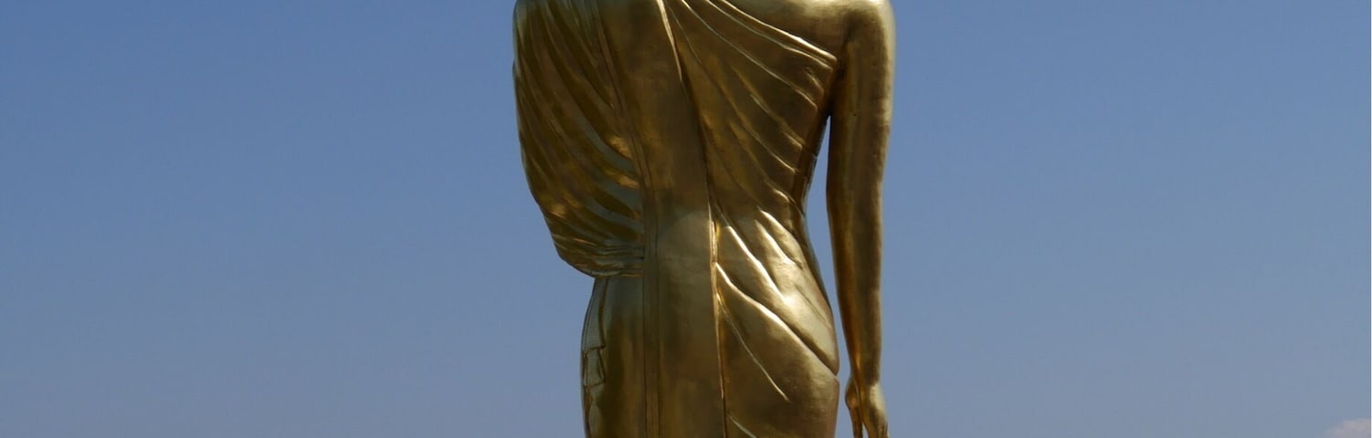Walking Buddha Statue at Wat Phra That Khao Noi overlooking the city of Nan, Thailand.