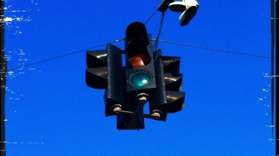 Somebody forgot their shoes next to the traffic signal...