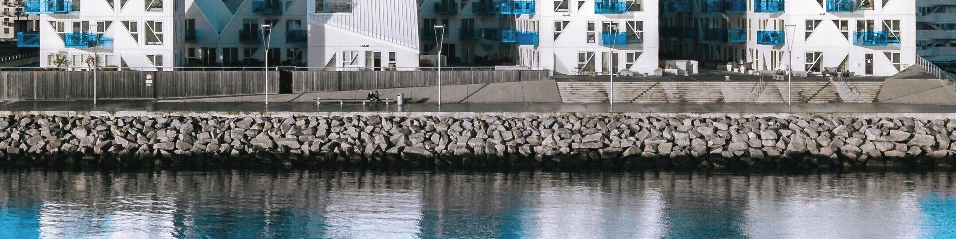 Un frente marítimo con edificios modernos que presentan diseños geométricos y balcones.
