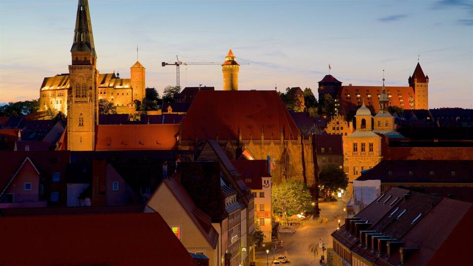 A historic town with prominent medieval architecture, including a church with a tall spire and a castle with multiple towers.
