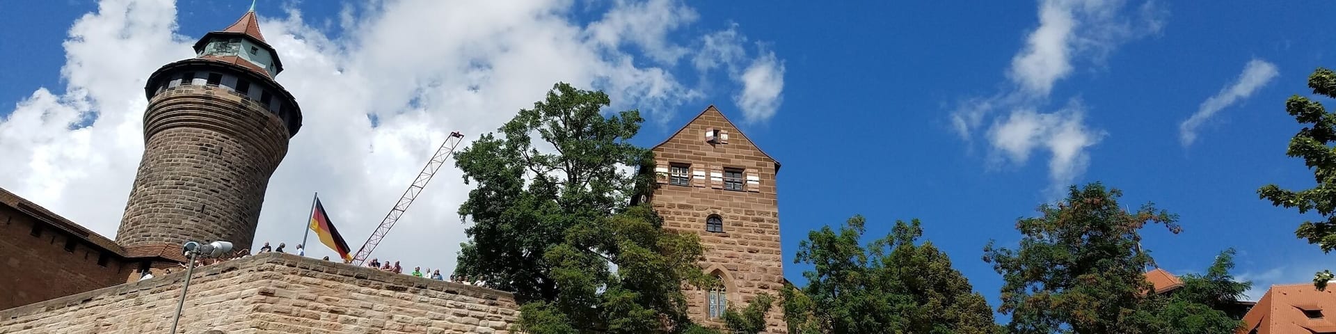 A historic castle with a prominent tower and a flagpole.