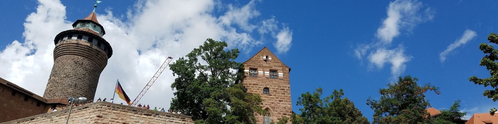 Un castillo histórico con una torre destacada y un asta de bandera.