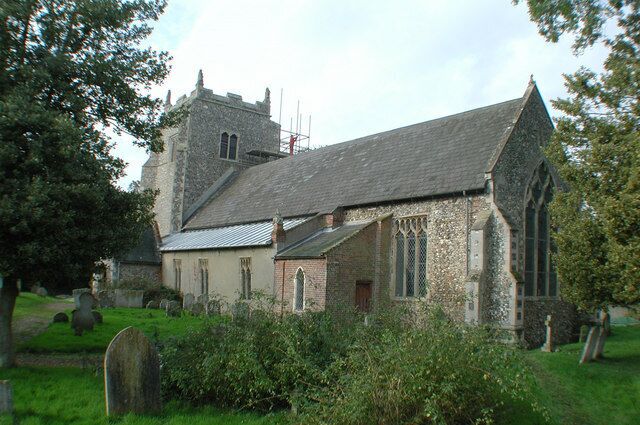 A church with a stone tower and a smaller building with a sloped roof.