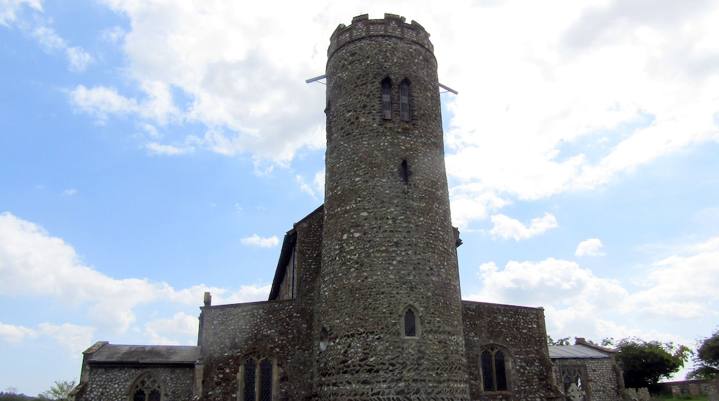 The west elevation and the round bell tower of the parish church of Saint Mary in the village of Roughton, Norfolk, England.