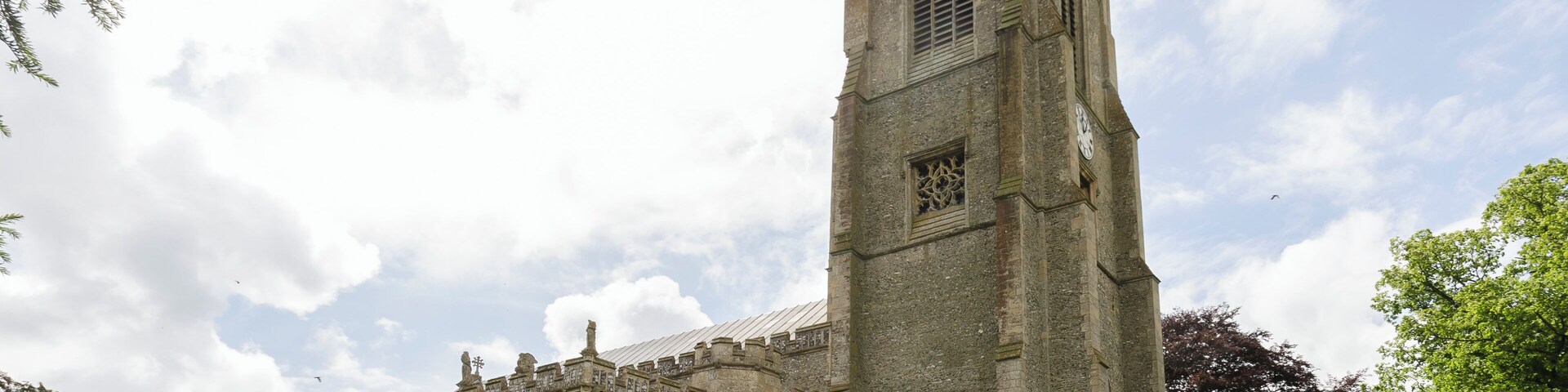 Una iglesia histórica con una torre alta y ventanas de arco.