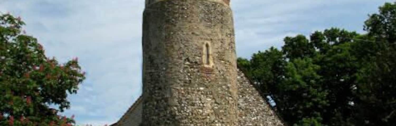 St Peter's Church (2). The image was taken from The Street, showing the west end and the 12th century round tower with its 15th century octagonal brick top. See here for other views of this church from south > 316156; north > 614994 and southeast > 614976. St Peter's church has a C12 round tower with an octagonal brick top > https://www.geograph.org.uk/photo/615006 which was added during the 15th century. Extensively restored during Victorian times > https://www.geograph.org.uk/photo/857907 - https://www.geograph.org.uk/photo/857913 there are not many older survivals, the most noteworthy being a number of C15 and C16 brasses, some in their original locations on the floor, some others mounted on the wall > https://www.geograph.org.uk/photo/857928. The church is usually open on weekends during the summer months. For more information see:
http://www.norfolkchurches.co.uk/brampton/brampton.htm